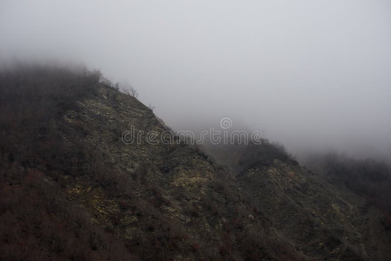 Panorama del paesaggio nebbioso di inverno nelle montagne con neve e rocce, Azerbaigian, Lahic, grande Caucaso fotografie stock Panorama del paesaggio nebbioso di inverno nelle montagne con neve e rocce, Azerbaigian, Lahic, grande Caucaso fotografie stock