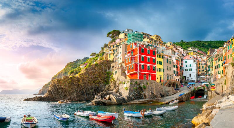 Panorama del viilage italiano famoso Riomaggiore della spiaggia al tramonto fotografia stock