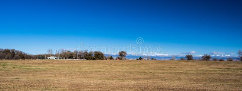Panorama des Feldes in West-Colorado mit Bauernhöfen und des Schnees mit einer Kappe bedeckt lizenzfreie stockfotografie Panorama des Feldes in West-Colorado mit Bauernhöfen und des Schnees mit einer Kappe bedeckt lizenzfreie stockfotografie