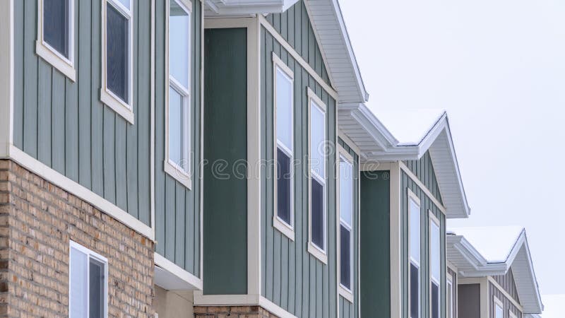 Panorama frame Vertical siding and stone brick wall at the townhomes upper storey against sky