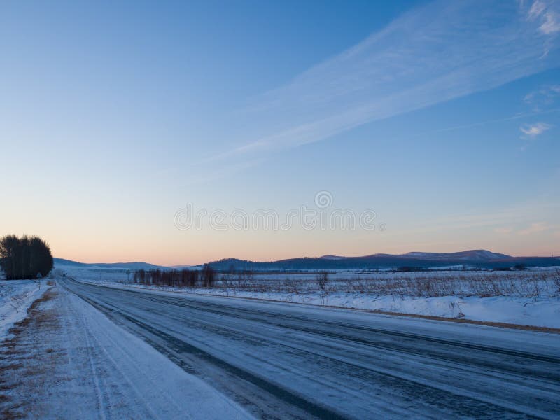 Panorama of the highway in winter Siberia. Sunrise over a snowy plain stock images Panorama of the highway in winter Siberia. Sunrise over a snowy plain stock images