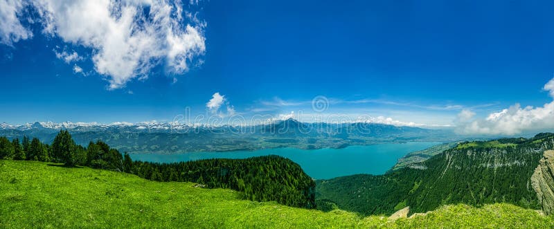 Panorama of Lake Thun and Bernese Alps including Jungfrau, Niesen, Eiger and Monch peaks from the top of Niederhorn in summer royalty free stock photo Panorama of Lake Thun and Bernese Alps including Jungfrau, Niesen, Eiger and Monch peaks from the top of Niederhorn in summer royalty free stock photo