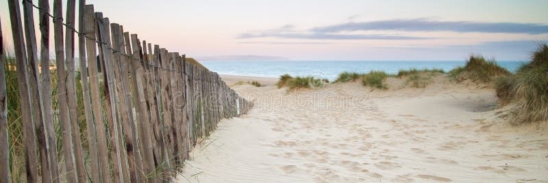 Panorama, un paesaggio di dune di sabbia sulla spiaggia all'alba.