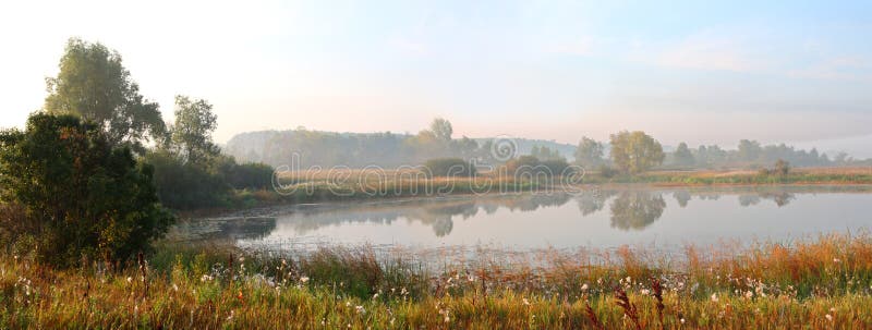 Panorama of morning lake in fog