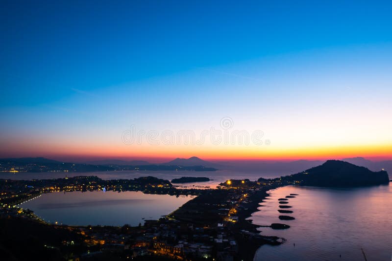 Panorama of Naples Italy, seen from `Monte di Procida `, `Campi Flegrei `, a few minutes before dawn, you can see the Vesuvius, the Miseno lake, the sea and the gulf, clear day. Panorama of Naples Italy, seen from `Monte di Procida `, `Campi Flegrei `, a few minutes before dawn, you can see the Vesuvius, the Miseno lake, the sea and the gulf, clear day