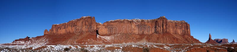 Panorama banner view from Monument Valley Navajo Indian Tribal Park, located in Utah and Arizona. The red ridge and mountains rise up from the desert floor to create a spectacular panoramic vista. Winter snow dusts the mesa rock formation and monolith. Practically every mountain in this part of the American west is jaw-dropping stunning. The blue sky you see here is real, it was not Photoshopped! Monument Valley is a popular destination for those on vacation or holiday. Panorama banner view from Monument Valley Navajo Indian Tribal Park, located in Utah and Arizona. The red ridge and mountains rise up from the desert floor to create a spectacular panoramic vista. Winter snow dusts the mesa rock formation and monolith. Practically every mountain in this part of the American west is jaw-dropping stunning. The blue sky you see here is real, it was not Photoshopped! Monument Valley is a popular destination for those on vacation or holiday.