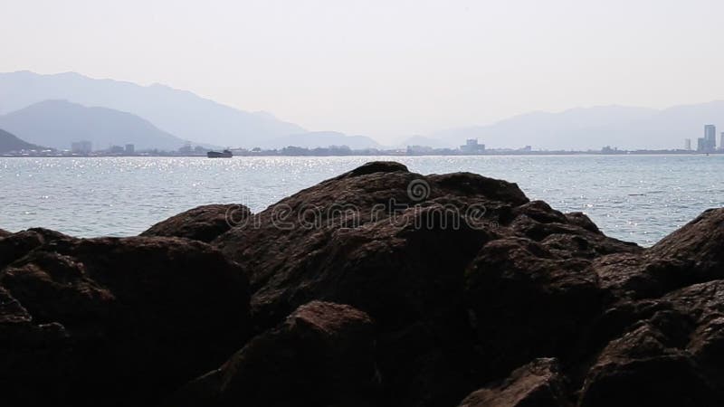 Panorama of seascape with stones blue ocean and skyline sity.