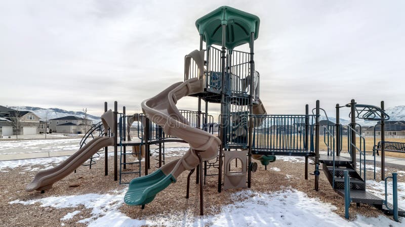Panorama Slides on a Playground with Snow on the Ground Against Homes ...