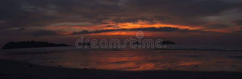 Panorama of spectacular sunset on beach with bright colors and no people on palm tree Koh Chang Island, Thailand