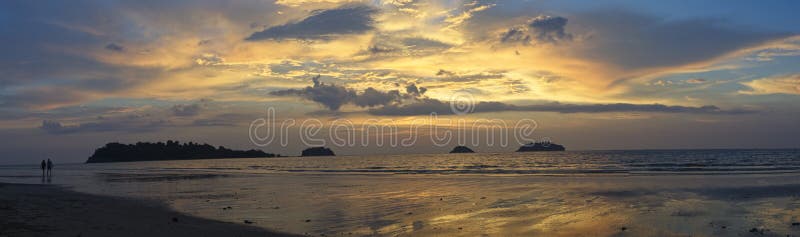 Panorama of spectacular sunset on deserted beach with bright colors and no people with palm trees on Koh Chang Island, Thailand