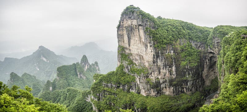 Panorama of the Tianmen Mountain Peak with a view of the cave Known as The Heaven`s Gate surrounded by the green forest and mist