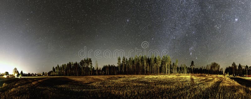 Panorama of very clear deep starry skies with Milky Way above harvested field and wild Scandinavian pine forest, autumn time royalty free stock images Panorama of very clear deep starry skies with Milky Way above harvested field and wild Scandinavian pine forest, autumn time royalty free stock images