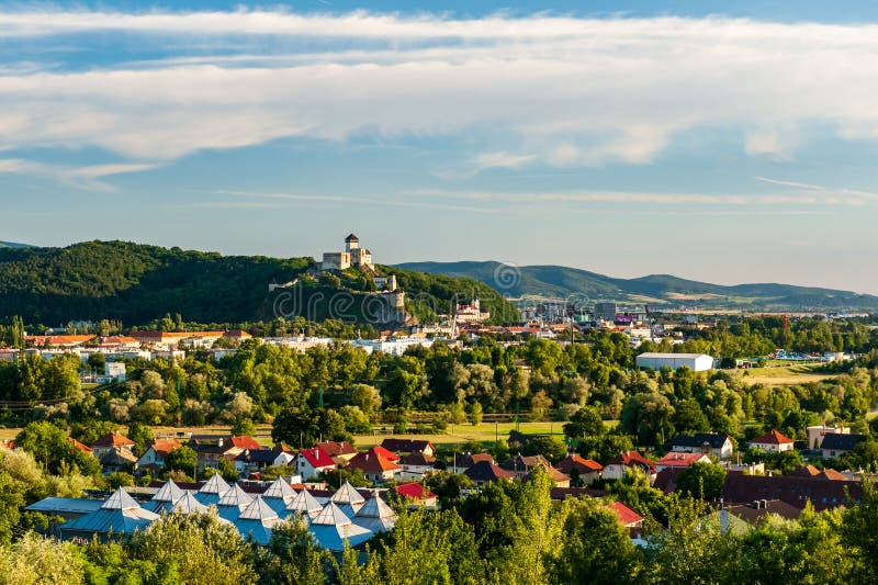 Panoramatický pohled na středověký nově zrekonstruovaný Trenčianský hrad nad řekou Váh s výhledem na město Trenčín za zlatého slunečného letního dne