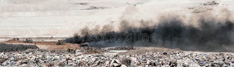 Fire at landfill site. Panorama of black smoke over burning old tyres and piles of garbage. Fire at landfill site. Panorama of black smoke over burning old tyres and piles of garbage