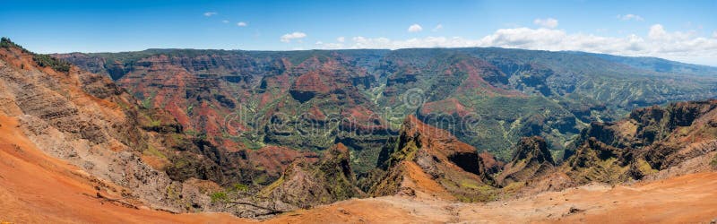 Early light illuminates the steep rock sides of panoramic view of Waimea Canyon on Kauai. Early light illuminates the steep rock sides of panoramic view of Waimea Canyon on Kauai