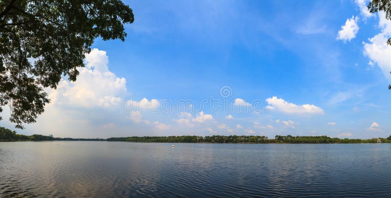 Panorama widok spokojny jezioro z niebieskiego nieba tłem zdjęcia stock Panorama widok spokojny jezioro z niebieskiego nieba tłem zdjęcia stock