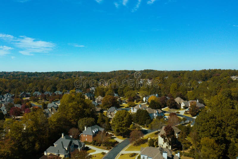 Aerial panoramic view of house cluster in a sub division in Suburbs with golf course and lake in metro Atlanta in Georgia ,USA shot by drone shot during golden hour. Aerial panoramic view of house cluster in a sub division in Suburbs with golf course and lake in metro Atlanta in Georgia ,USA shot by drone shot during golden hour