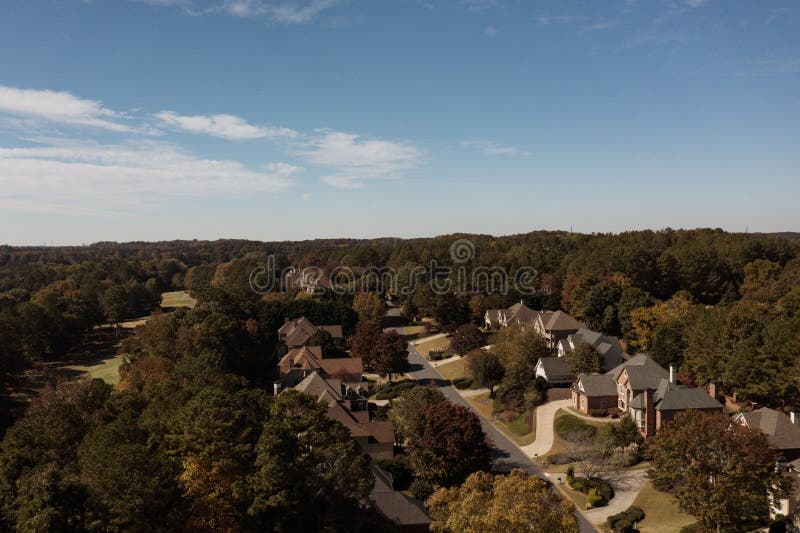 Aerial panoramic view of house cluster in a sub division in Suburbs with golf course and lake in metro Atlanta in Georgia ,USA shot by drone shot during golden hour. Aerial panoramic view of house cluster in a sub division in Suburbs with golf course and lake in metro Atlanta in Georgia ,USA shot by drone shot during golden hour