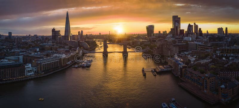 Panoramic aerial view to the modern skyline of London with the Tower Bridgeduring a colorful sunset, United Kingdom. Panoramic aerial view to the modern skyline of London with the Tower Bridgeduring a colorful sunset, United Kingdom