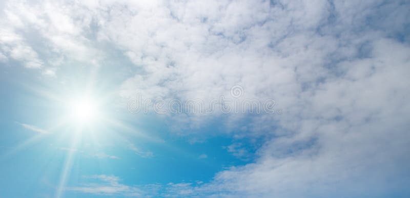 Panoramic Bright Blue Sky with Radiant Sun and White Clouds royalty free stock photo