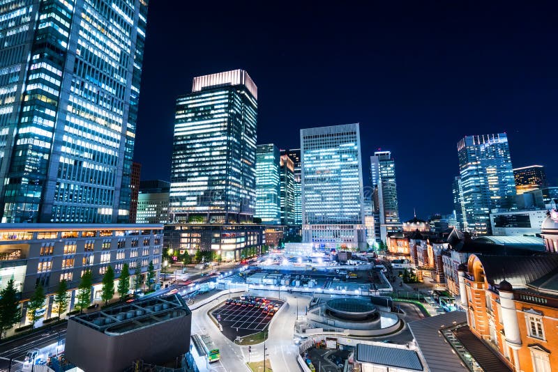 Panoramic modern city skyline bird eye aerial night view with tokyo station under dramatic glow and beautiful dark blue sky in To