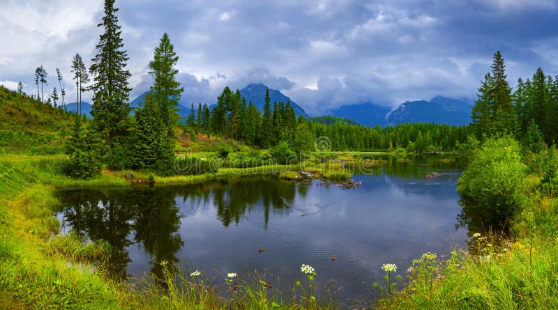 Panoramic picture of beautiful mountain lake Strbske Pleso at summer evening.