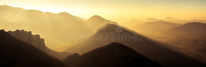 Panoramatický scénický výhľad na siluetu hôr a kopcov pri západe slnka