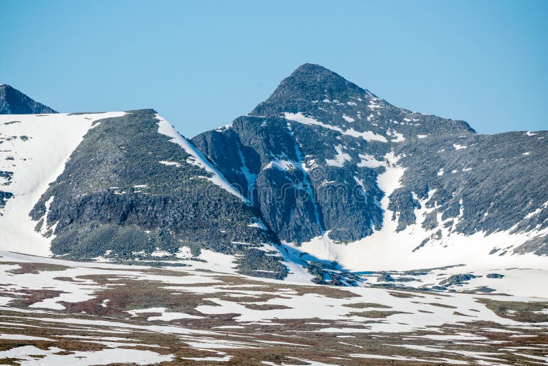 Panoramic shot of beautiful mountain peaks and landscape scenery in spring with snow capped mountains stock photo