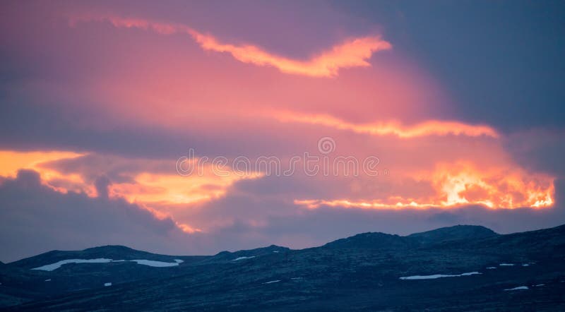 Panoramic shot of mountain scenery during sunset, blue hour and pink dramatic skies and light stock photo