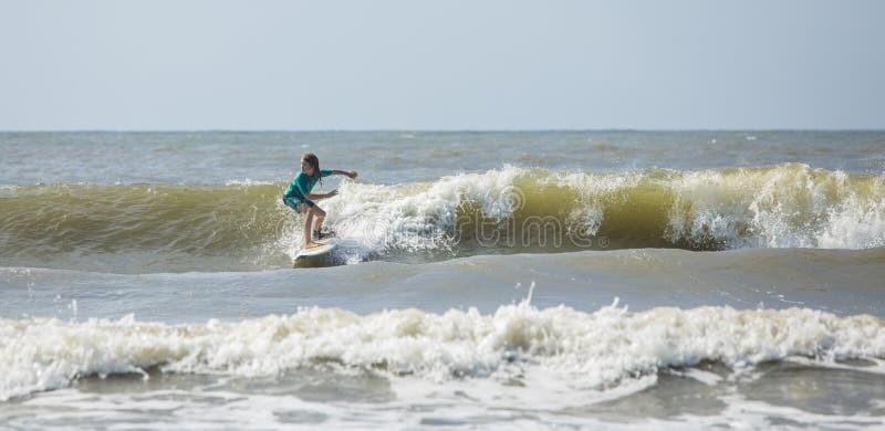 Panoramic shot of talented kid surfing waves on the Atlantic Ocean stock image