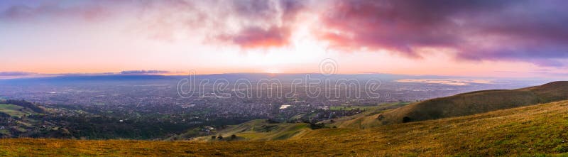 Panoramic sunset view of San Jose and South San Francisco Bay Area, also known as Silicon Valley; hills starting to turn green