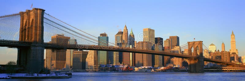 Panoramic view of Brooklyn Bridge and East River at sunrise with New York City, NY skyline post 9/11 view