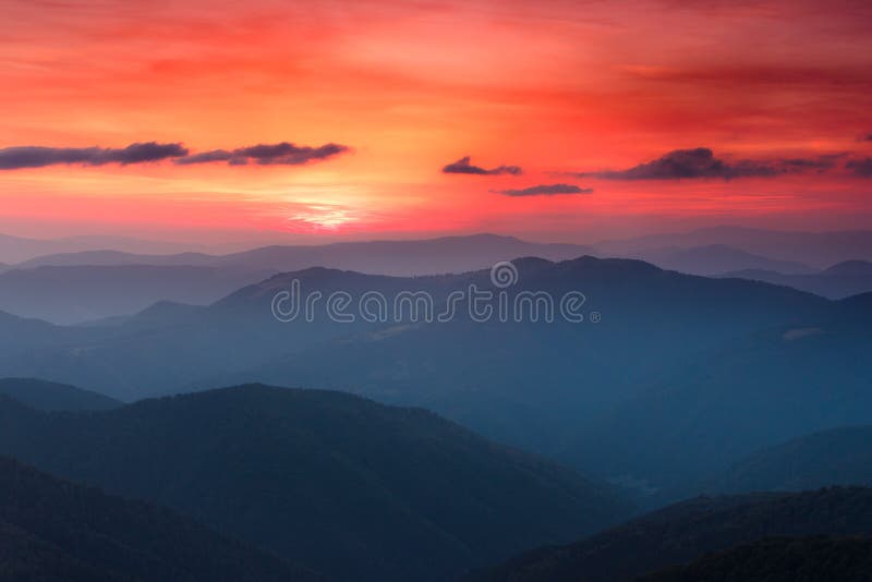 Panoramic view of colorful sunset in the mountains. Dramatic overcast sky.