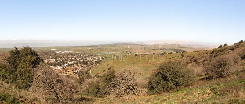 A panoramic view from Mount Benthal of the nearby valley, settlements, fields, wind turbines and the snow-capped peak of Mount Hermon, in the Golan Heights, in northern Israel. A panoramic view from Mount Benthal of the nearby valley, settlements, fields, wind turbines and the snow-capped peak of Mount Hermon, in the Golan Heights, in northern Israel