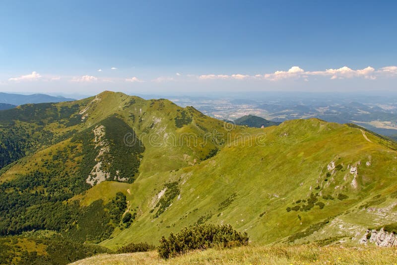 Panoramic view on mountain ridge, National park Mala Fatra, Slovakia. Green mountain vegetation, town in distant valley. royalty free stock photo Panoramic view on mountain ridge, National park Mala Fatra, Slovakia. Green mountain vegetation, town in distant valley. royalty free stock photo