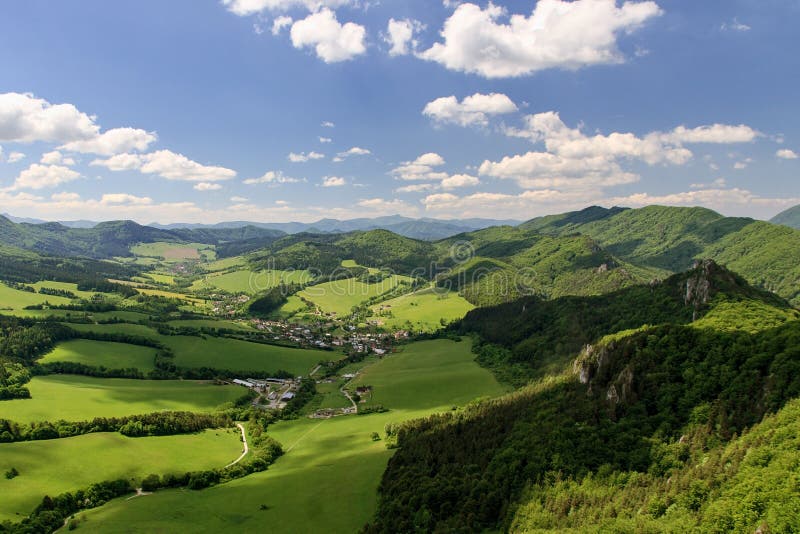 Panoramic view of Sulov village from Sulov rocks, Sulovske skaly national nature reserve, Slovakia. Green meadows and fields.