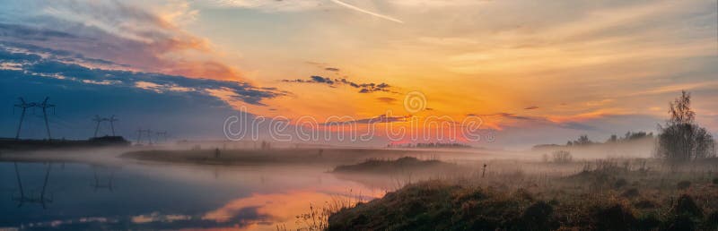 Panoramic view of the sunrise over the lake, beautiful landscape with morning fog, breathtaking summer sunrise. The beauty of natu