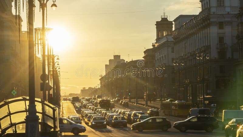 Panoramic view of sunset between the buildings in the city. At the end of the road the sun sets on the horizon