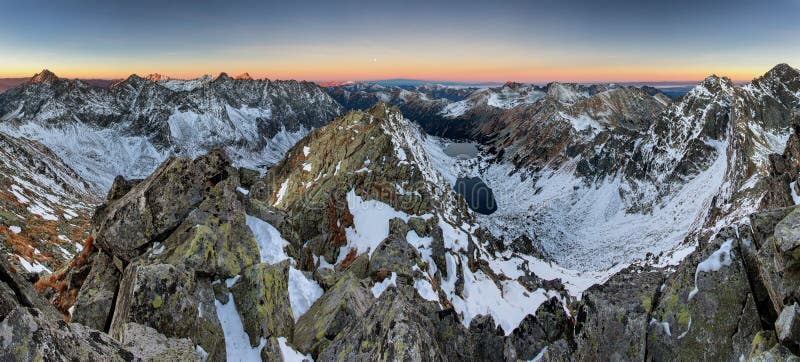 Panoramic view of white winter mountains with colorful sunset -