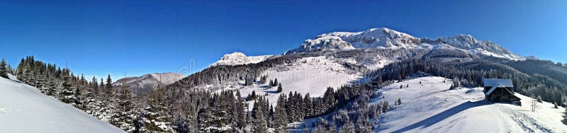 Mountains and forest during winter season. Sunny day in the mountains during winter time. Mountains and forest during winter season. Sunny day in the mountains during winter time.