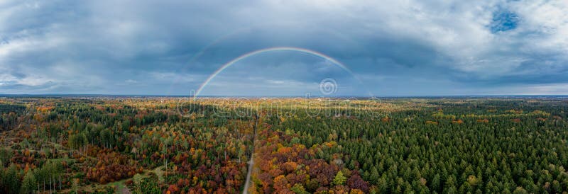 Panoramico doppio arcobaleno di una foresta di colore autunnale con vista sulla linea bavarese di Monaco di Baviera fotografia stock libera da diritti