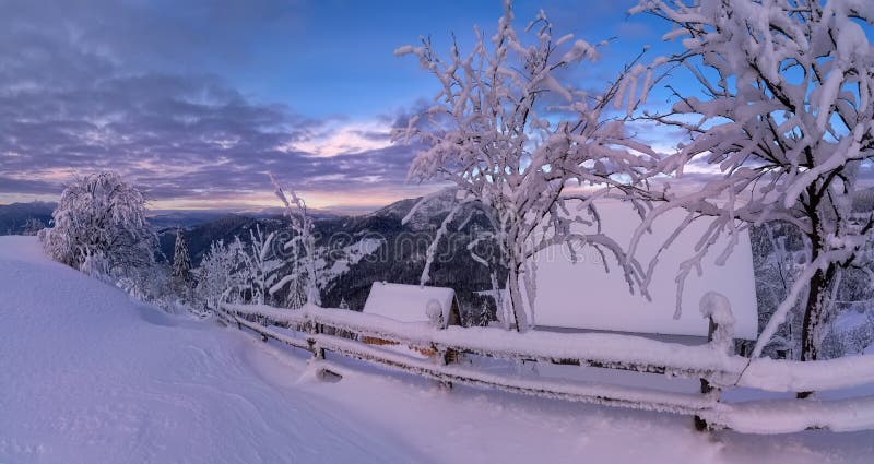 Panoramiczny widok Piękny góra krajobraz W menchii brzmieniach Z śnieżystym domem, drzewami I Drewnianym ogrodzeniem Przy wschód zdjęcie royalty free Panoramiczny widok Piękny góra krajobraz W menchii brzmieniach Z śnieżystym domem, drzewami I Drewnianym ogrodzeniem Przy wschód zdjęcie royalty free