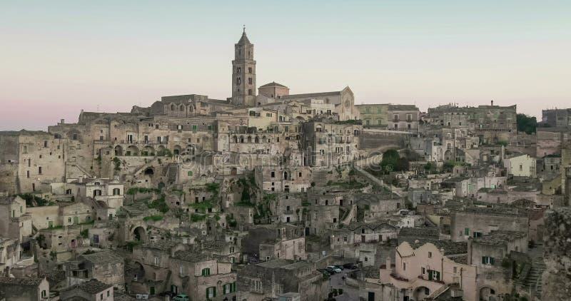 Panoramiczny widok typowi kamienie i kościół Matera pod zmierzchu niebem