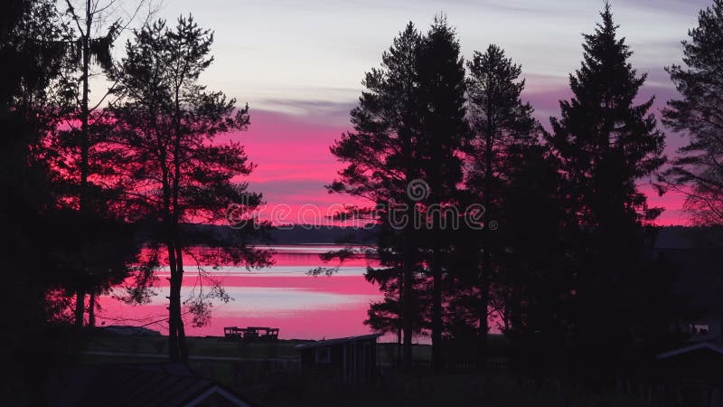 Panoramique vidéo de rouge orange brûlant le ciel de minuit après le coucher du soleil. lumière nuits d'été proche du milieu de l' banque de vidéos