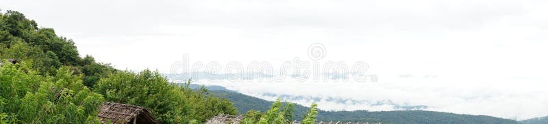 Panoramisk syn pÃ¥ bergen och den abstrakta dimman pÃ¥ himlen, en skogstrandad bergsluttning i ett moln med lÃ¥g liggande yta med arkivbild Panoramisk syn pÃ¥ bergen och den abstrakta dimman pÃ¥ himlen, en skogstrandad bergsluttning i ett moln med lÃ¥g liggande yta med arkivbild