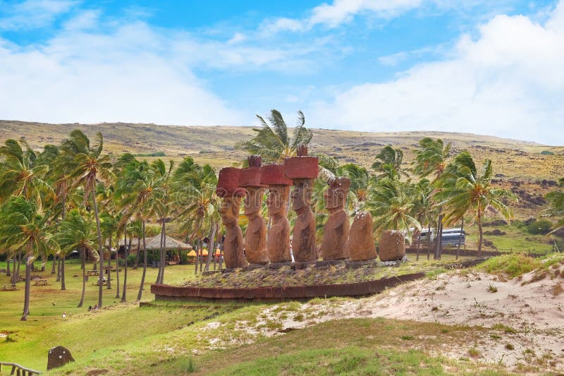Panoramisk syn på palmgroven vid anakena-stranden och moai-statyer vid ahu Nonao-ceremonialcentret på påsk arkivfoto