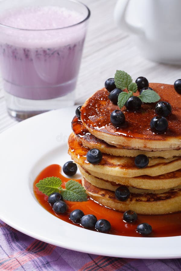 Panquecas de mirtilo com xarope de ácer e um cocktail em close-up imagens de stock
