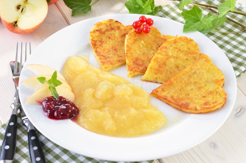 Baked potato pancakes in the shape of a heart with applesauce, cranberries and redcurrants. Baked potato pancakes in the shape of a heart with applesauce, cranberries and redcurrants