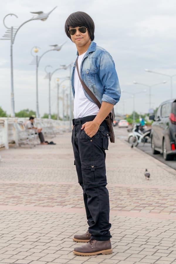 Un Jeune Homme Cool Portant Du Bandana Fixe Sa Manche Image stock