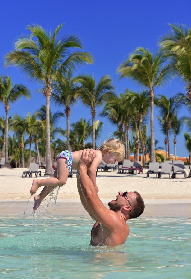 Papa tenant l'enfant de bébé dans des vacances tropicales de plage de mer de mains